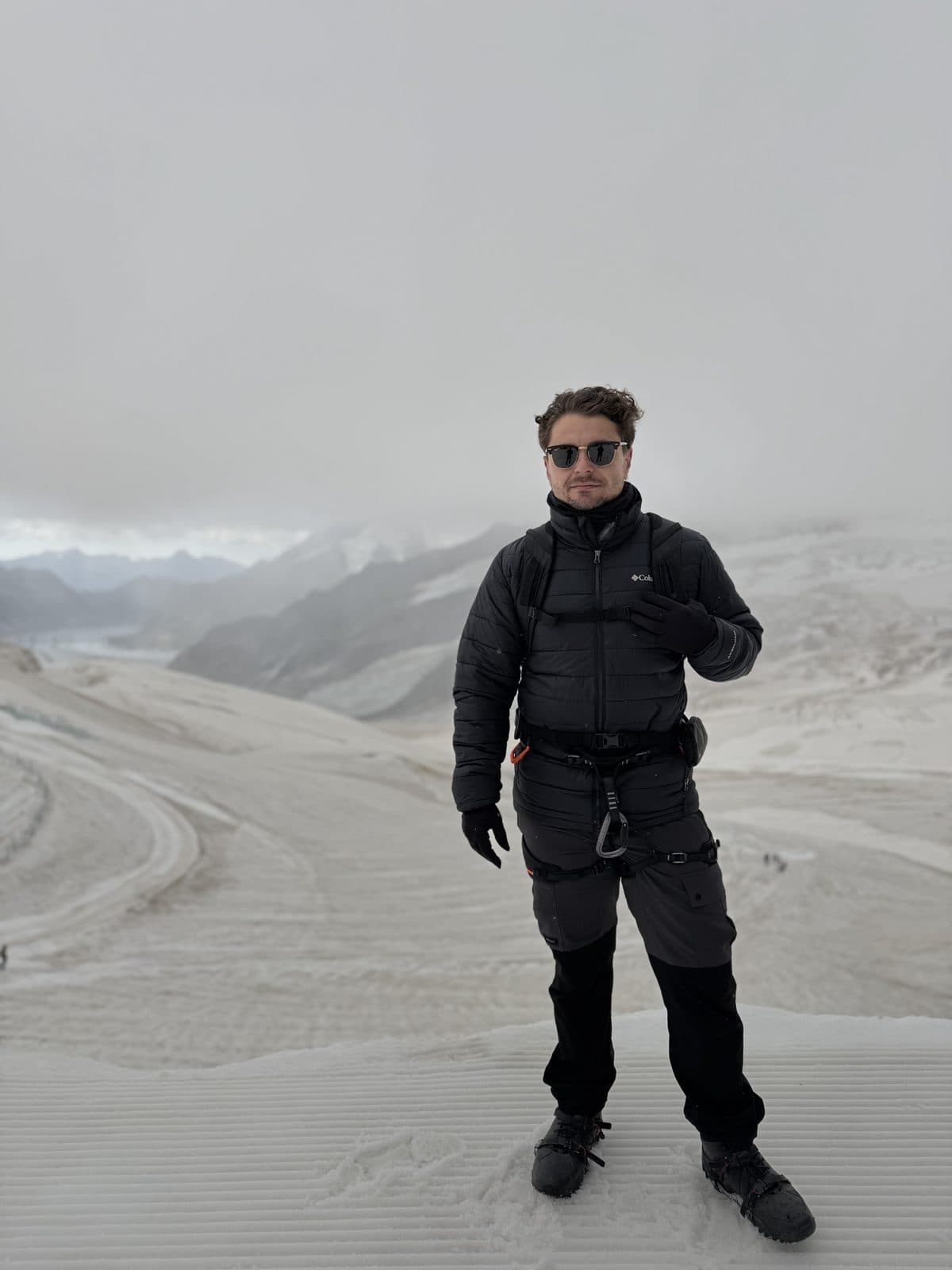 Florian Raschle in glacier gear on the Aletsch glacier, fog and ice behind him