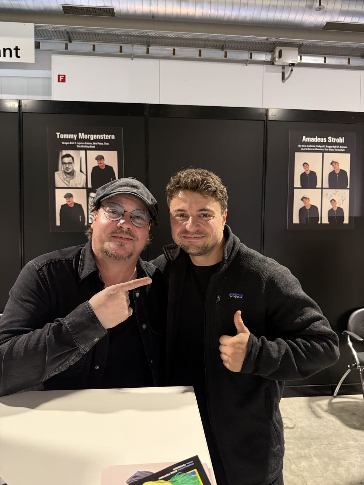 Florian Raschle with the voice actor of Son Goku at a fan meet, one pointing at the other, thumbs up