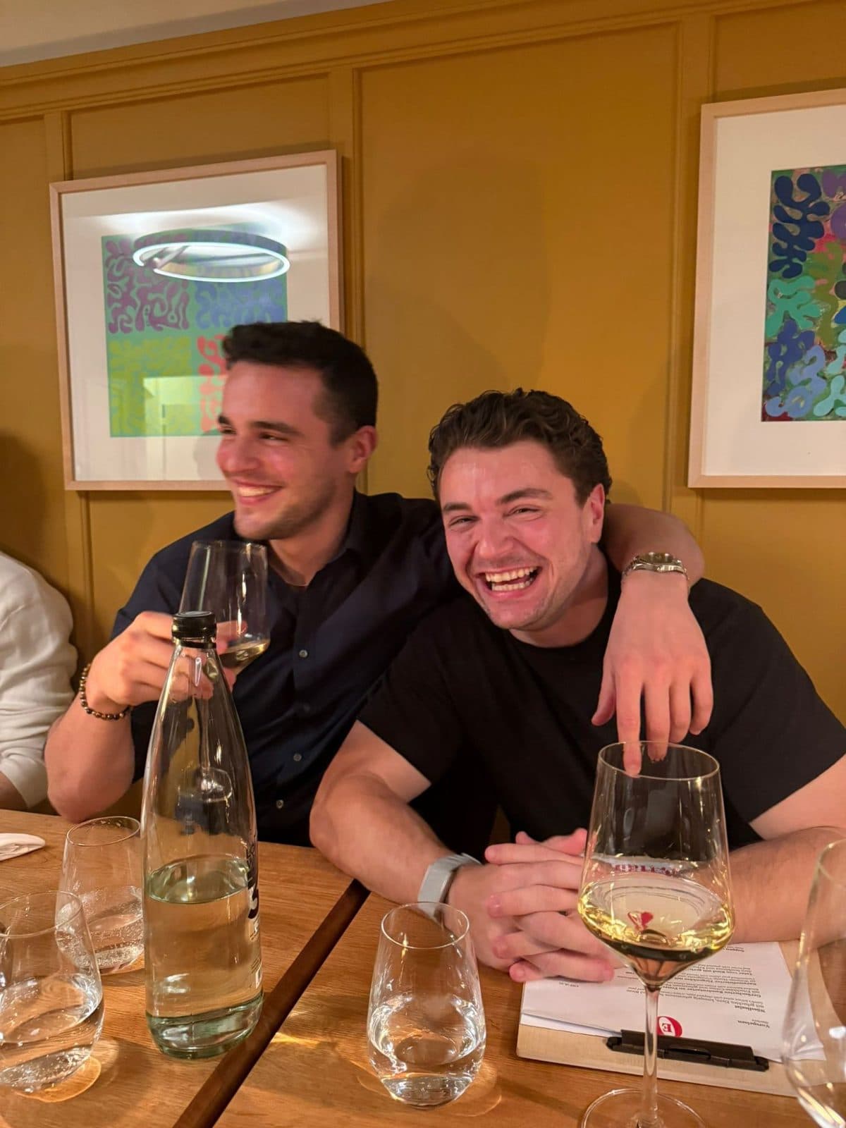Florian Raschle laughing with a friend at a restaurant table